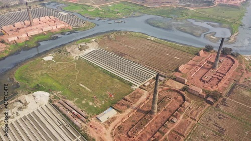 Aerial view of several chimneys from a brick factory along Buriganga river near Keraniganj township, Dhaka province, Bangladesh. photo