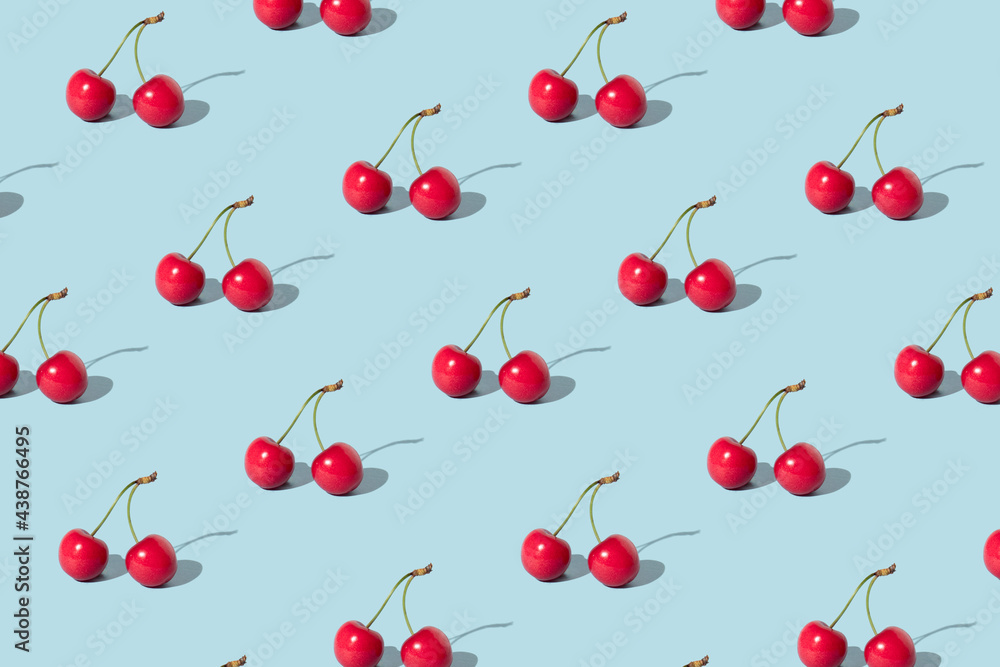 Creative pattern made with red cherries on pastel blue background. Summer or spring fruit concept. Minimal aesthetic idea. Creative pattern made with red cherries on pastel blue background. Summer or spring fruit concept. Minimal aesthetic idea.