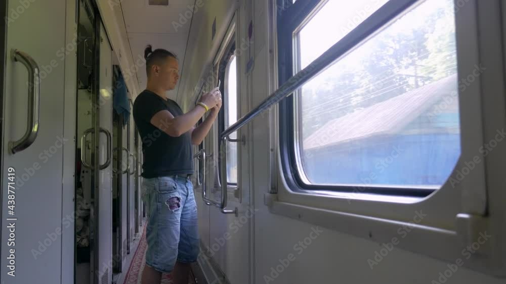 Man taking photo in train out window. Using mobile application on smartphone Man taking photo in train out window. Using mobile application on smartphone