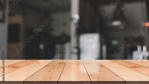 Empty wooden table top with lights bokeh on blur restaurant background. © DEEP PIXEL