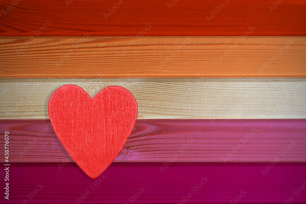 On the wooden background of the LGBT flag is a heart.Symbol of the month of pride of the lesbian community.Meaning-transgenderism and femininity,community,gender-uncomfortable people,freedom,love. On the wooden background of the LGBT flag is a heart.Symbol of the month of pride of the lesbian community.Meaning-transgenderism and femininity,community,gender-uncomfortable people,freedom,love.