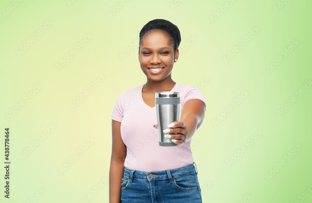 sustainability, eco living and people concept - portrait of african american woman in turquoise shirt with thermo cup or tumbler for hot drinks over green background sustainability, eco living and people concept - portrait of african american woman in turquoise shirt with thermo cup or tumbler for hot drinks over green background