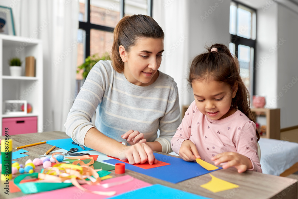 family, art and craft concept - mother spending time with her little daughter making applique of color paper at home family, art and craft concept - mother spending time with her little daughter making applique of color paper at home