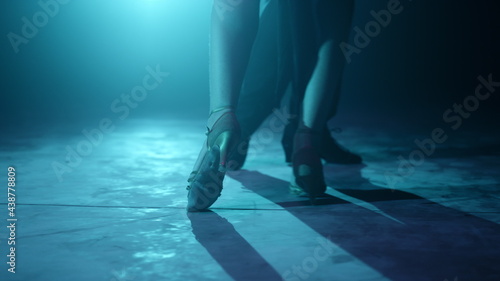 Closeup dancers legs dancing indoors. Partners feet doing latin dance steps.