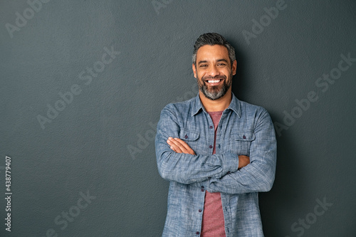 Smiling mixed race mature man on grey background