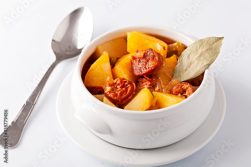 Patatas a la riojana, potatoes stew with chorizo on white background photo