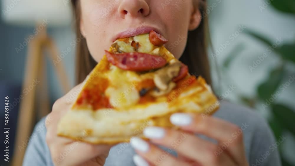 Woman eating pizza. Close-up. Concept of quick bites and unhealthy food Woman eating pizza. Close-up. Concept of quick bites and unhealthy food