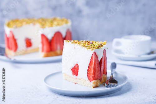 Freesier cake with fresh strawberries and pistachios. French classic dessert. Portion of cake on a white plate close-up. photo