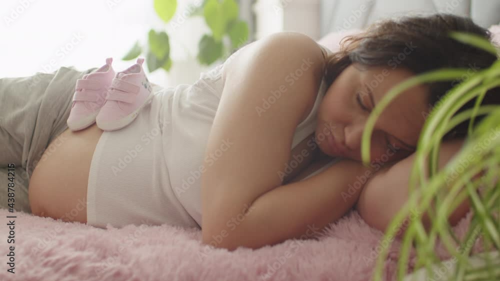 Pregnant woman expecting a baby resting in the bedroom. Pregnant adult woman sleeping at home alone. Woman pregnancy and maternity prenatal care. Slow motion 4K video. Pregnant woman expecting a baby resting in the bedroom. Pregnant adult woman sleeping at home alone. Woman pregnancy and maternity prenatal care. Slow motion 4K video.