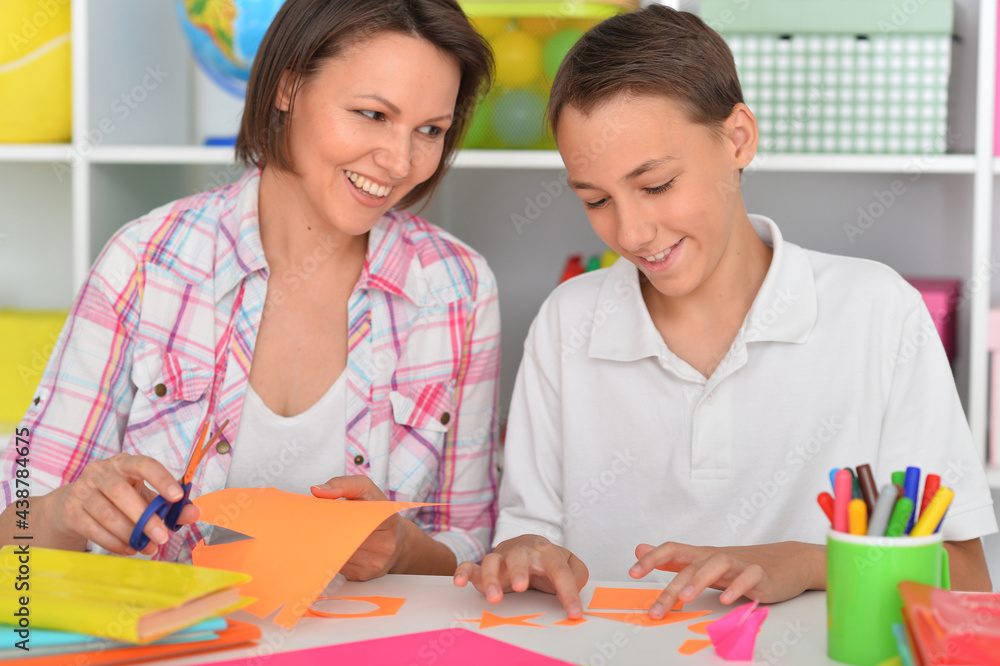 Porait of mother teaches her son to do craft items Porait of mother teaches her son to do craft items