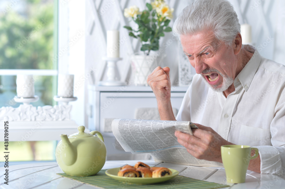 Fototapeta premium Senior man reading newspaper
