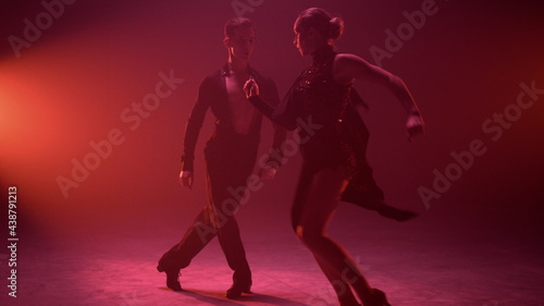 Sexy dancers enjoying performance on stage. Sensual couple dancing samba indoors