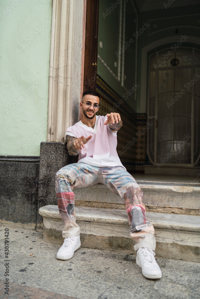 Chico joven guapo tatuado posando en entornos urbanos con ropa a la moda  Photos | Adobe Stock