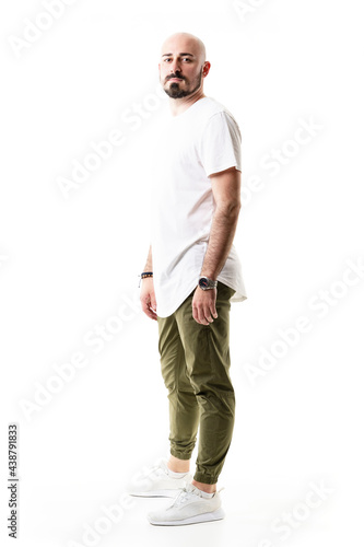 Casual modern trendy bald bearded hipster posing with arms down. Full body length isolated on white background