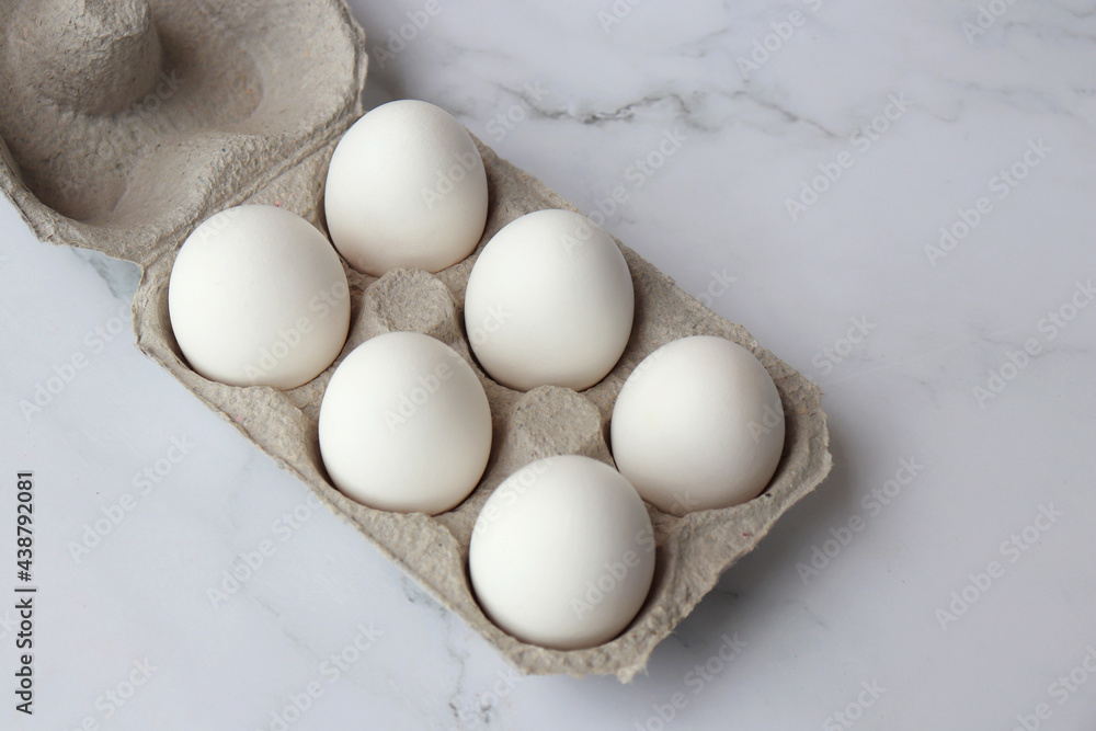 Cardboard egg rack with white eggs on white background. six Hen eggs tray. White Chicken Eggs online shopping product photography. copy space. Cardboard egg rack with white eggs on white background. six Hen eggs tray. White Chicken Eggs online shopping product photography. copy space.