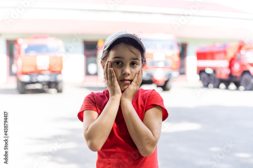 little girl near fire trucks