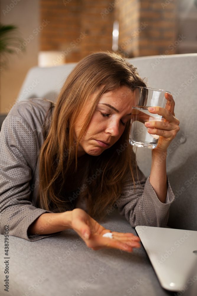 Sick woman at home. Young woman drinking medicine, having fever.. Sick woman at home. Young woman drinking medicine, having fever..