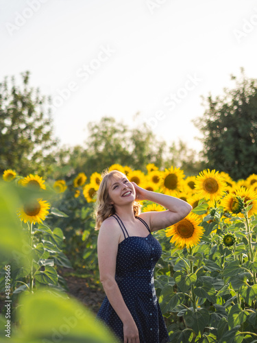Mujer joven guapa disfrutando de las flores en un campo de girasoles