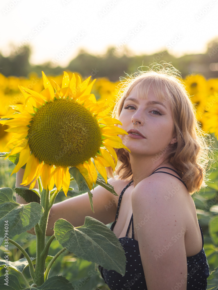 Mujer joven disfrutando del verano en un campo de girasoles Mujer joven disfrutando del verano en un campo de girasoles