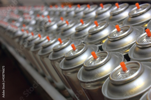 Aerosol cans on conveyor belt being manufactured