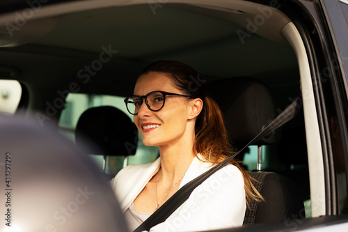 Beautiful businesswoman driving a car. Portrait of smiling woman sitting in the car...