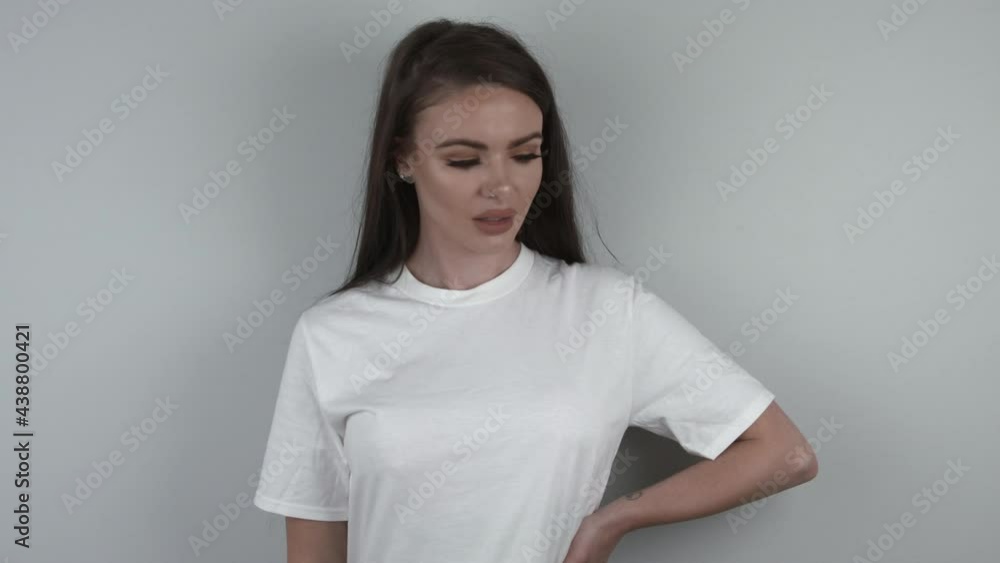 Pretty model in white t-shirt flirting. Girl on white background with a smile moving and eyeing up the camera. Pretty model in white t-shirt flirting. Girl on white background with a smile moving and eyeing up the camera.