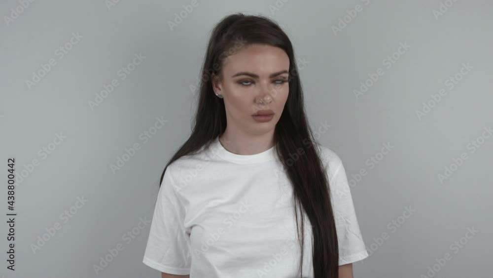 Pretty woman in white t-shirt expressing her boredom. Girl on white background rolling her eyes while sighing and huffing. Pretty woman in white t-shirt expressing her boredom. Girl on white background rolling her eyes while sighing and huffing.