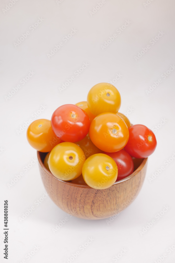 red and yellow color cherry tomato in a bowl on white background 