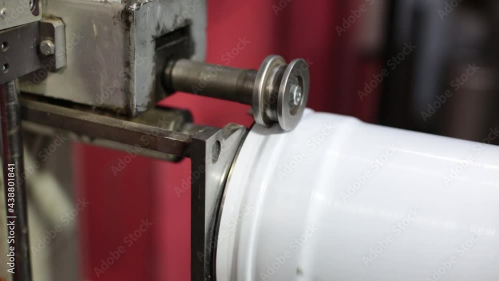 Manufacturing of ventilation and drainage pipes. A man works with a production rolling tool, an electric machine. Tools and equipment for bending sheet metal.