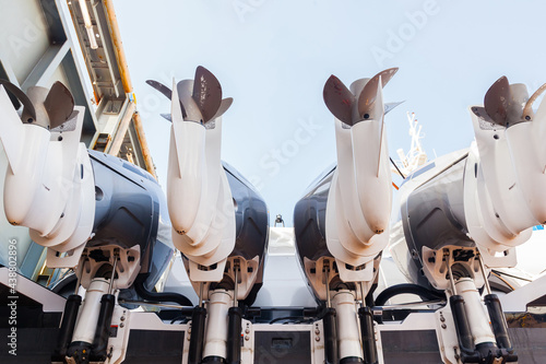 Foto Four outboard outboard motors against the sky, mounted on a boat in dry dock, bottom view
