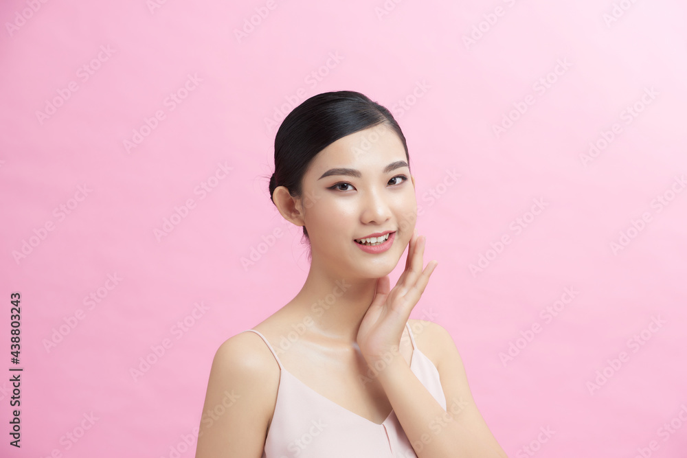 Young woman applying cream onto her skin against color background Young woman applying cream onto her skin against color background