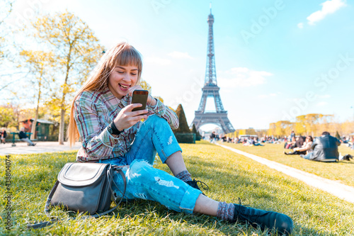 Canvas Print Happy girl using phone in Paris with Eiffel Tower on background