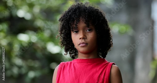 Serious child standing outside looking at camera. Brazilian black girl ethnicity photo