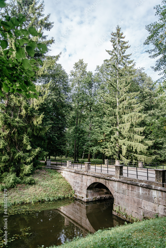 An old authentic bridge over a river in a public historic park. An old authentic bridge over a river in a public historic park.