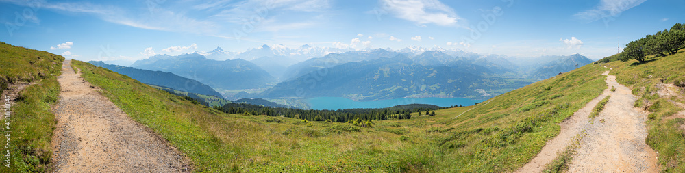 hiking trail at wide Niederhorn mountain ridge, with vew to swiss alps Bernese Oberland and lake Thunersee