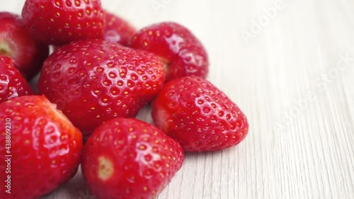 Red strawberry on wooden background close up spinning