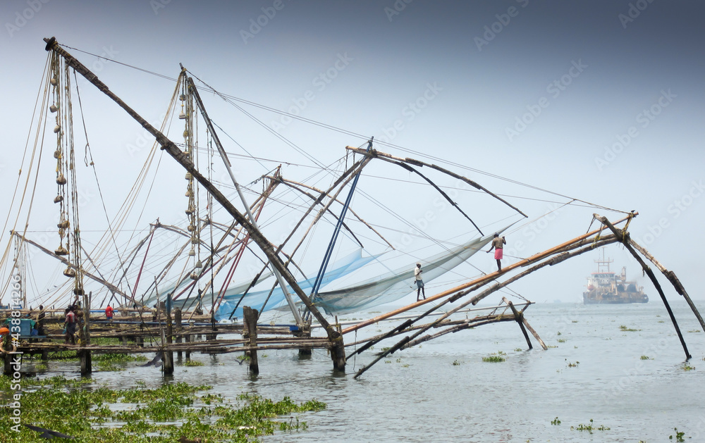 An Ancient traditional method of fish catching in Kerala state, popularly  called as the Chinese fishing nets where natives have made this as a means  of Livelihood in India. Stock Photo
