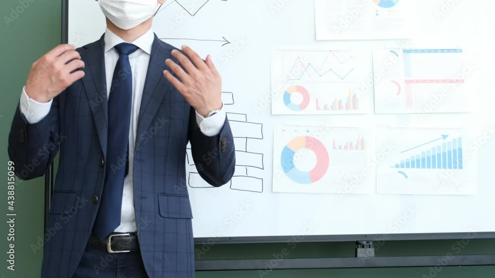 ホワイトボードの前でプレゼンするサラリーマン男性