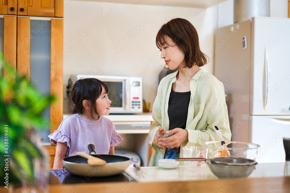 お母さんと一緒に料理をする女の子
