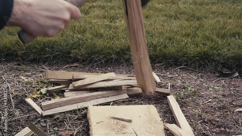 Wallpaper Mural Splitting oak wood into small chips to light a fire outdoors in slow motion Torontodigital.ca