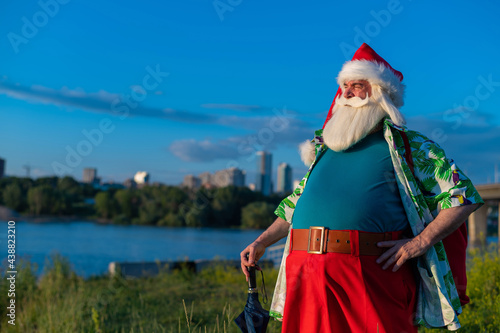 Santa Claus in a Hawaiian shirt is walking in nature. Christmas in the tropics