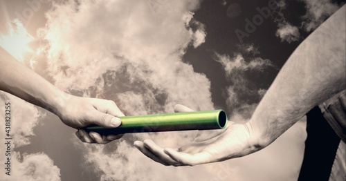 Bilde på lerret Composition of caucasian athletes passing green relay baton over clouds