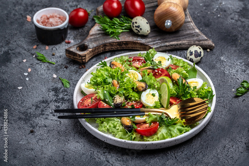Salad with mussels, quail, egg, conjugate lime, spinach, lettuce, cherry tomatoes and microgreen. Dietary salad. Food recipe background. Close up