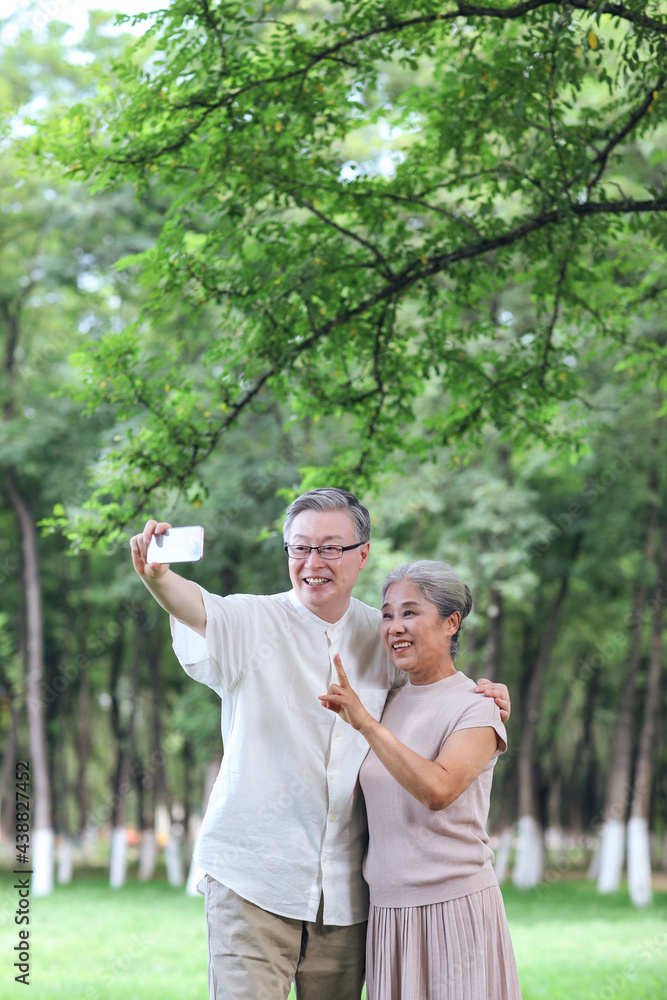 Obraz premium Happy old couple take selfie with mobile phone in park