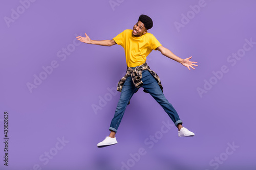 Full length body size view of attractive cheerful sly guy jumping having fun good mood isolated over violet purple color background