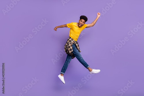 Full length body size view of attractive cheery funky guy jumping having fun running fooling isolated over violet purple color background