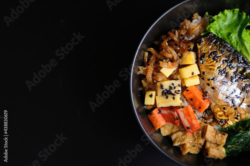 Saba on top of rice. Japanese food style, Saba fish grilled with teriyaki sauce in bowl with black background.