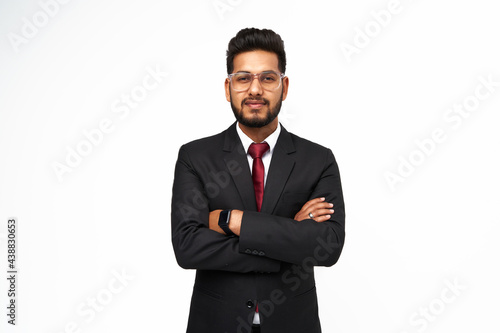 Portrait of young indian businessman with crossed arms on white isolated background