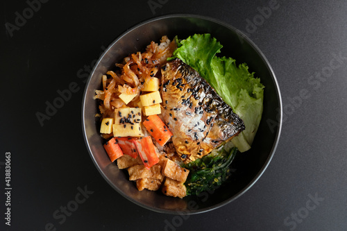 Saba on top of rice. Japanese food style, Saba fish grilled with teriyaki sauce in bowl with black background.