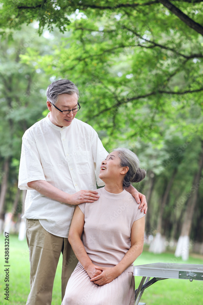 Happy old couple sitting on chairs in outdoor park Happy old couple sitting on chairs in outdoor park